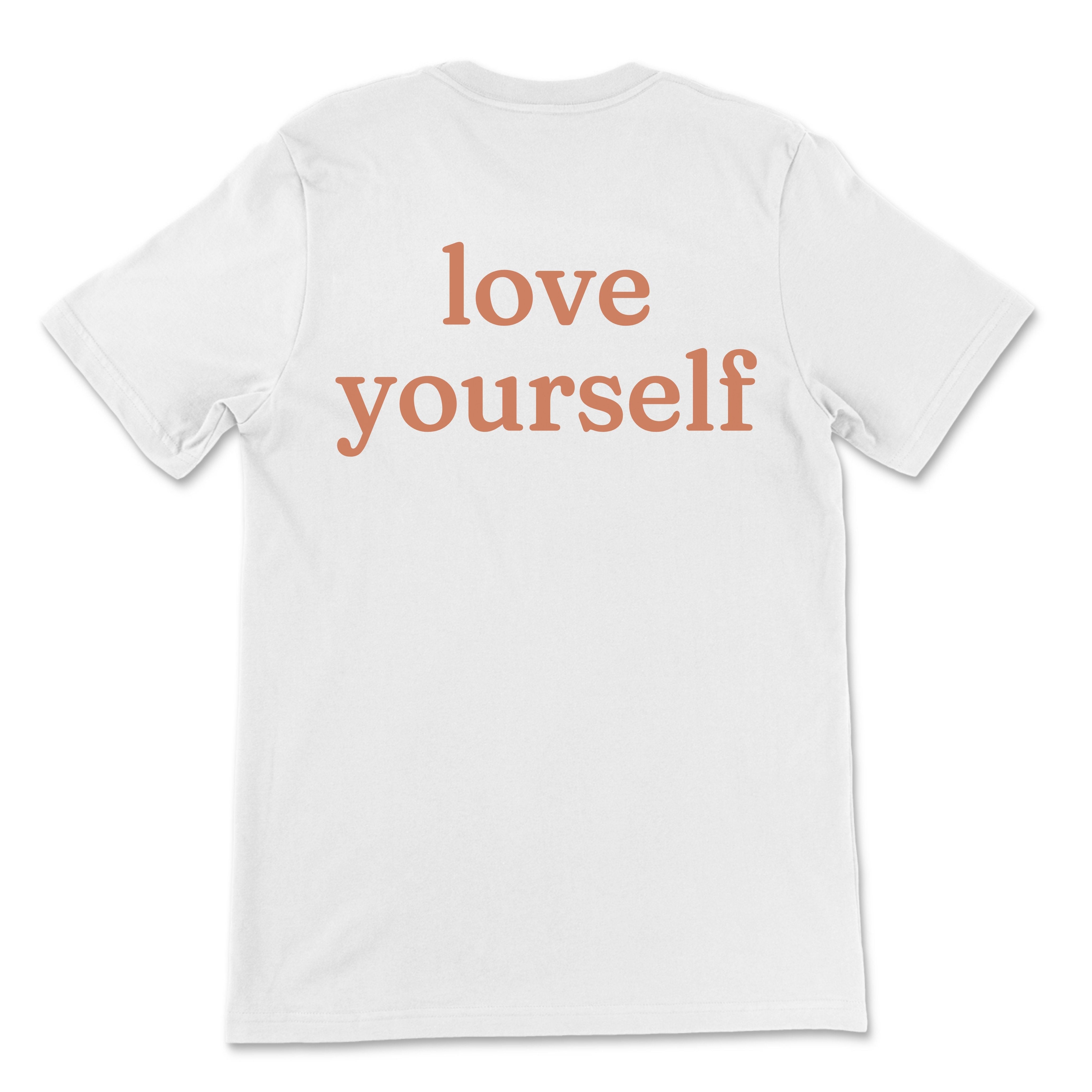 Natural tee with small “be kind” text on front chest and bold “love yourself” text across back