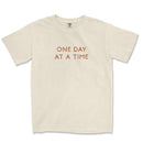 Neutral toned tee with take it one day at a time printed on back, styled casually for an everyday look