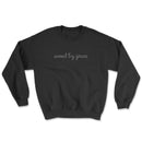 Light-colored sweatshirt with “Saved by Grace” text on front and full Ephesians 2:8 verse on back
