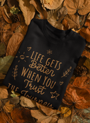 Black turtleneck sweater with text on leaves